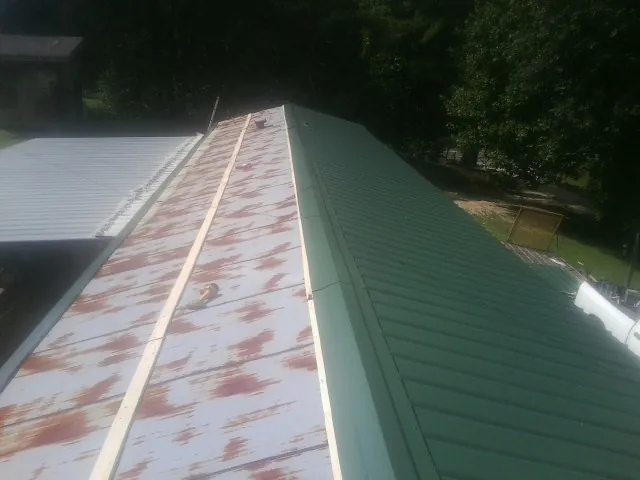 Old rusted panels beside newly installed green metal roofing — Wind Damage Roof Repair by Roofing Brothers in Lebanon