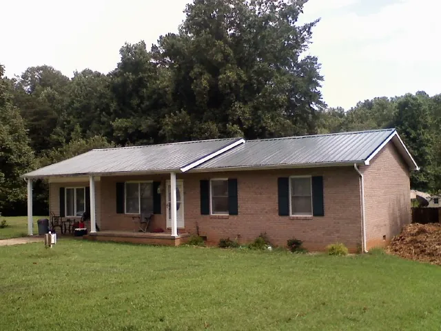 Gray metal roof on a brick ranch house with a side carport in Lebanon